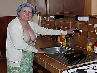 Une femme âgée séduit et s'engage dans une activité sexuelle sur le lit.